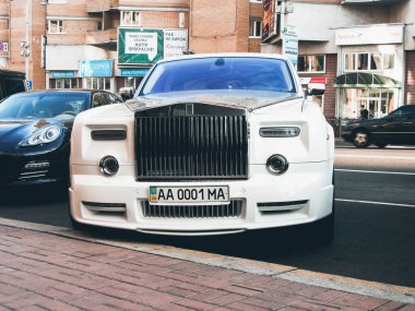 Kiev, Ukrayna - 25 Eylül 2010: Beyaz lüks İngiliz arabası Rolls-Royce Phantom Manual Conquistador ve Porsche Panamera şehirde park halindedir.