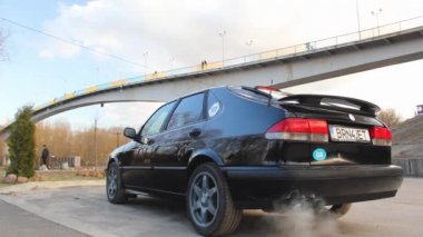 Chernihiv, Ukrayna - 20 Mart 2021: Eski İsveç arabası Saab 900 Turbo köprünün arka planında