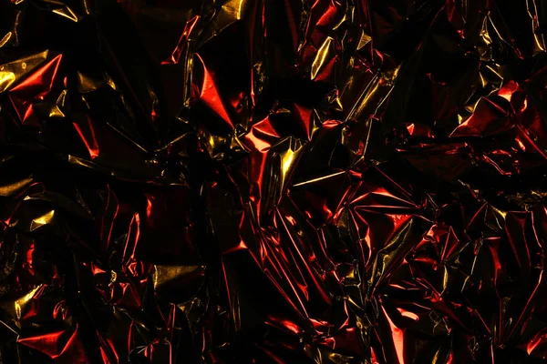 Foil background. Crumpled foil. Abstract background. Wallpaper. Red, orange and black