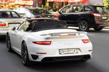Kiev, Ukrayna - 22 Mayıs 2021: Beyaz süper araba Porsche 911 Turbo S Cabriolet yolda