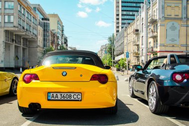 Kiev, Ukrayna - 22 Mayıs 2021: Sarı ve siyah BMW Z4 şehirde. Renkli BMW arabalar