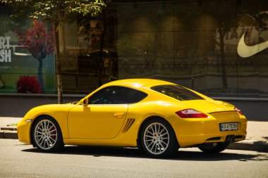 Kiev, Ukrayna - 12 Haziran 2021: Sarı süper araba Porsche Cayman şehirde park halinde