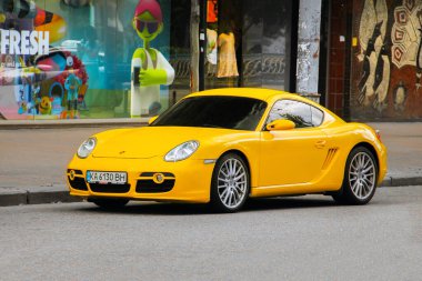 Kiev, Ukrayna - 12 Haziran 2021: Sarı süper araba Porsche Cayman şehirde park halinde
