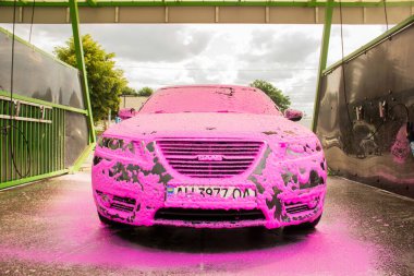 Chernigov, Ukrayna - 24 Temmuz 2021: Oto yıkamadaki Saab arabası. Pembe köpüklü gri Saab 9-5 arabası oto yıkamada.