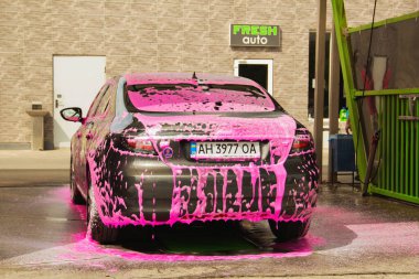 Chernigov, Ukrayna - 24 Temmuz 2021: Oto yıkamadaki Saab arabası. Pembe köpüklü gri Saab 9-5 arabası oto yıkamada.