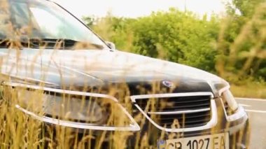 Chernigov, Ukrayna - 24 Temmuz 2021: Saab arabaları doğanın arka planına karşı yolda. Siyah araba Saab 9-5 SportCombi