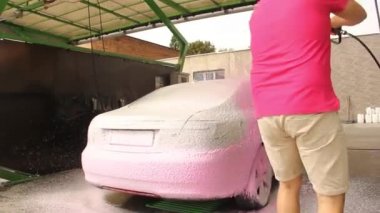 Chernigov, Ukrayna - 24 Temmuz 2021: Araba yıkayan bir adam. Araba yıkamada Saab 9-5 pembe köpüklü gri Saab araba oto yıkama servisinde.