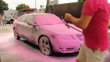 Chernigov, Ukrayna - 24 Temmuz 2021: Araba yıkayan bir adam. Araba yıkamada Saab 9-5 pembe köpüklü gri Saab araba oto yıkama servisinde.