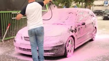 Chernigov, Ukrayna - 24 Temmuz 2021: Bir adam araba yıkar. Araba yıkamada pembe köpüklü Saab 9-3 oto yıkamada.