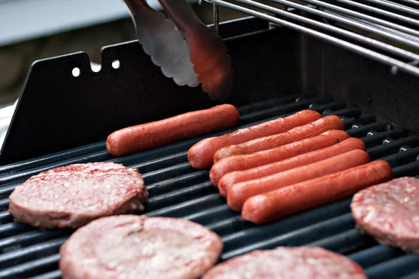 Hotdogs en hamburgers op de grill — Stockfoto