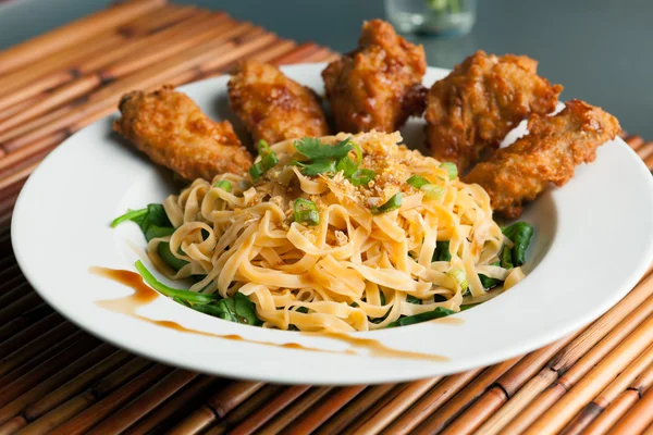 Asas de frango com macarrão e espinafre — Fotografia de Stock