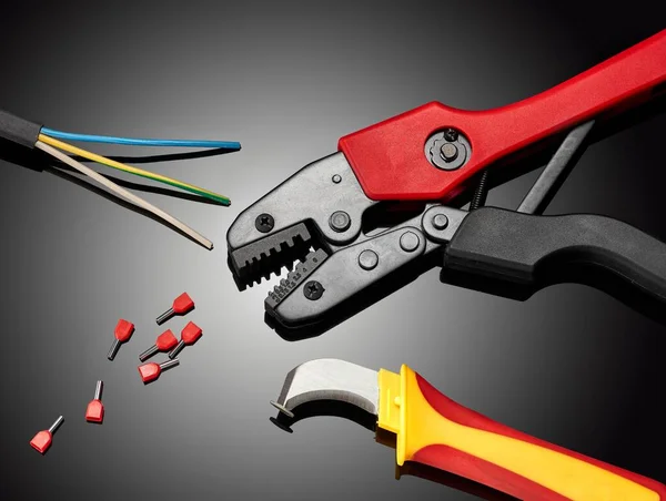 A crimping tool for an electrician on a dark background. Royalty Free Stock Photos