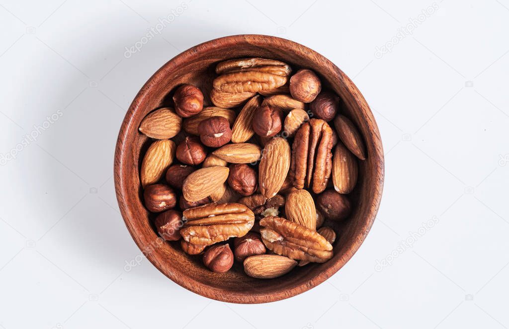 Mixed nuts in wooden bowl on white background.protein source. Isolated.