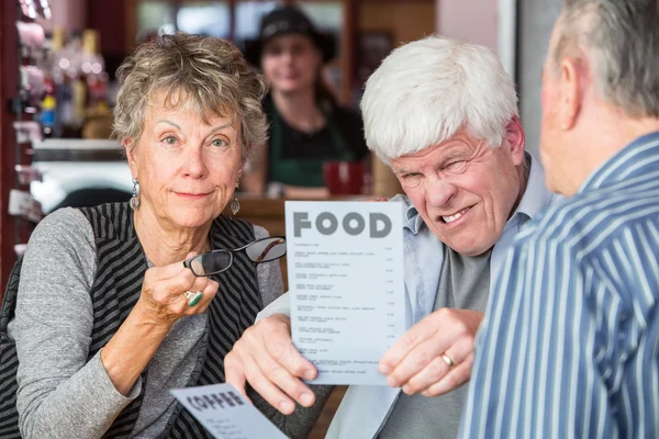 Mogen Man försöker läsa menyn utan glasögon — Stockfoto