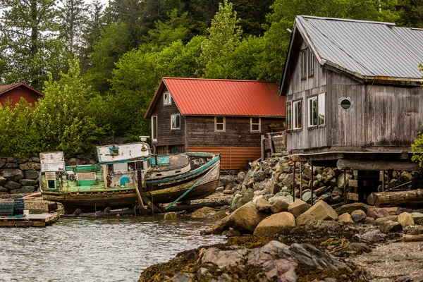 Waterfront buildings and an abandoned boat — Stock Photo, Image