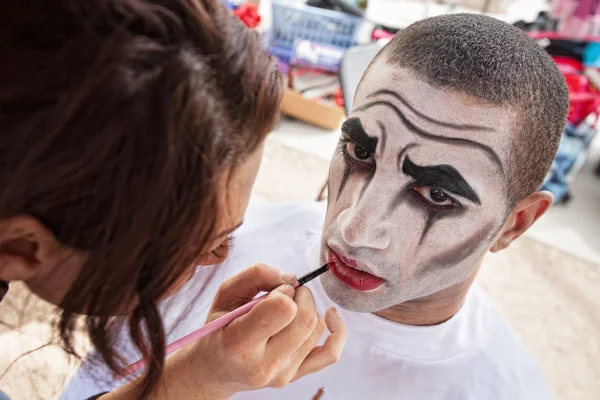 Makeup artist lining lips of circus clown — Stock Photo, Image