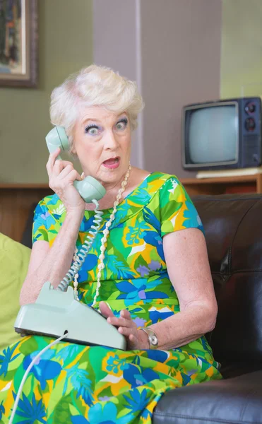 Удивлённая женщина разговаривает по вращающемуся телефону — стоковое фото