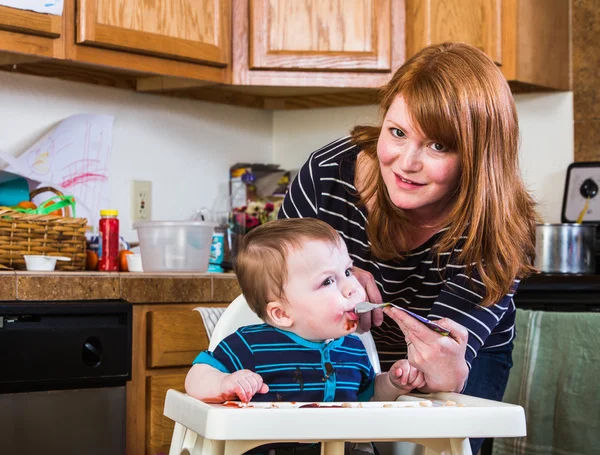 Woman Feeds Baby in Kitchen — Stock Photo, Image