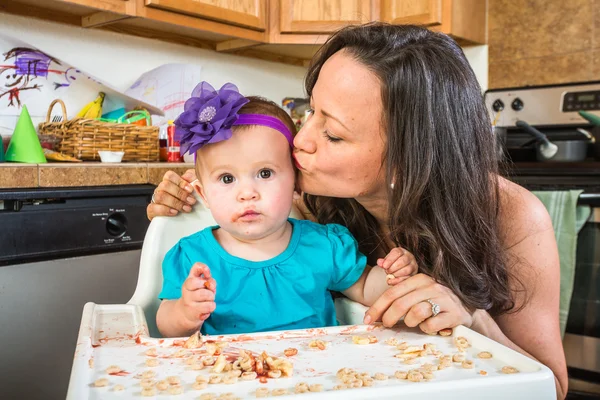 Kadın Kisses bebek mutfakta — Stok fotoğraf