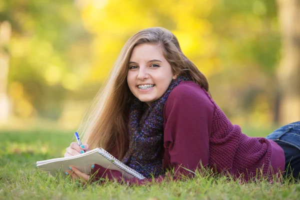 Adolescente femenina en tierra estudiando — Foto de Stock