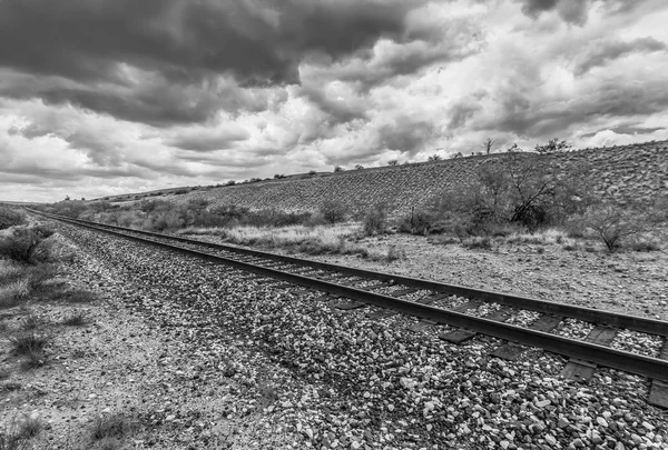 Dramatische wolken en lege Rails in woestijn — Stockfoto