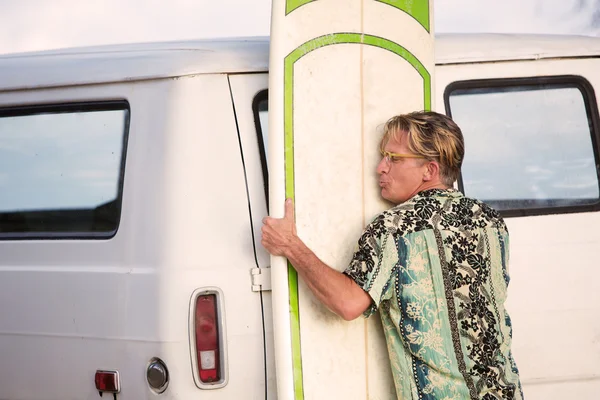 Człowiek do podnoszenia ciężkich deska surfingowa — Zdjęcie stockowe