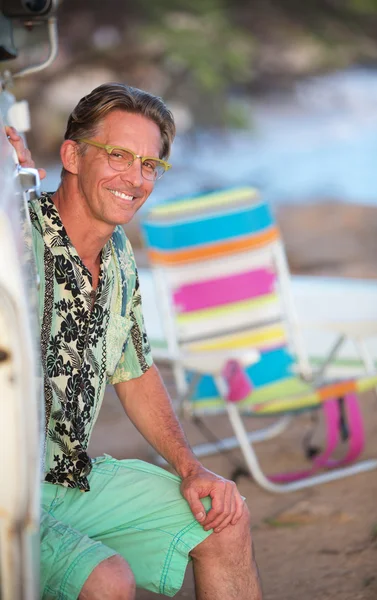 Hombre sonriente sentado en la playa —  Fotos de Stock
