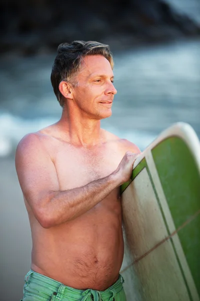 Självsäkra mannen med gröna surfbräda — Stockfoto