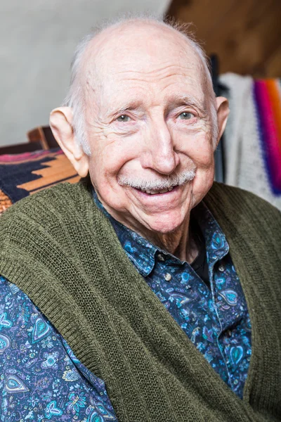 Older gentleman in green vest smiling — Stock Photo, Image