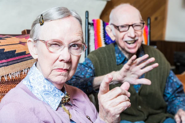 Par i vardagsrummet kvinna som pekar — Stockfoto