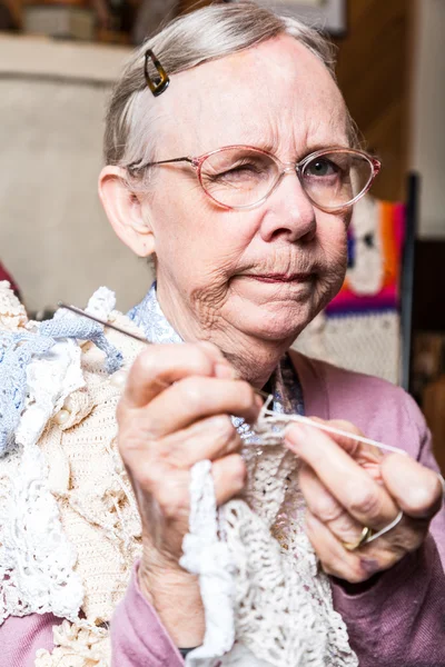 Old woman crocheting at home — Stock Photo, Image