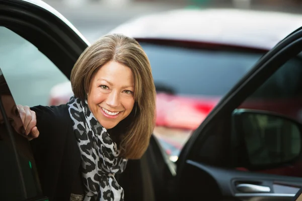 Businesswoman sitting in car with open door — Stock Photo, Image