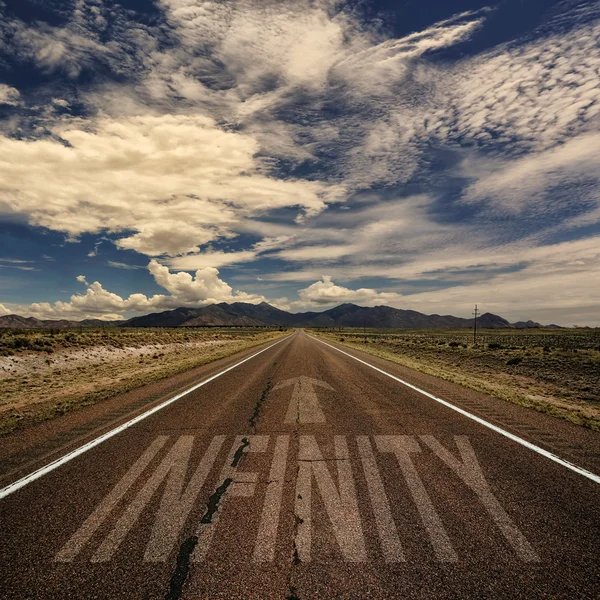 Woestijn weg met de word-infinity — Stockfoto
