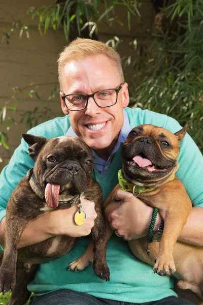 Köpekler çifti ile gülümseyen adam — Stok fotoğraf