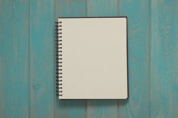 Cuaderno sobre escritorio de madera azul . — Foto de Stock