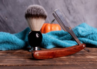 Razor, ahşap bir arka planda fırça ve havlu