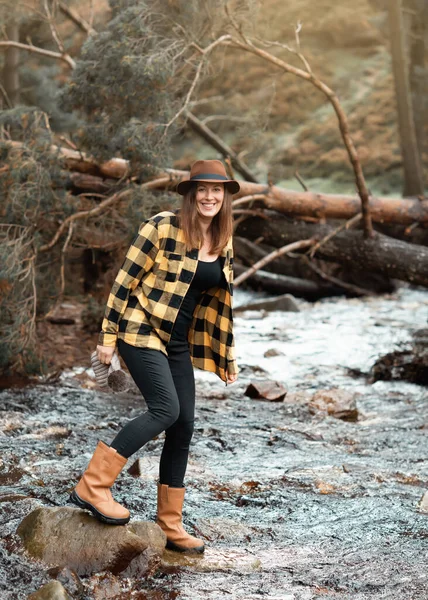 Sarı Gömlekli Şapkalı Kadın Sonbahar Ormanında Nehir Boyunca Yürüyor — Stok fotoğraf