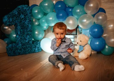 Balonlu bebek mavi balonlarla doğum gününü kutluyor.