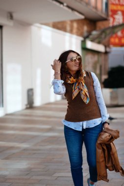 Deri ceketli ve kot pantolonlu Asyalı bir kadın Avrupa 'da dolaşıyor.