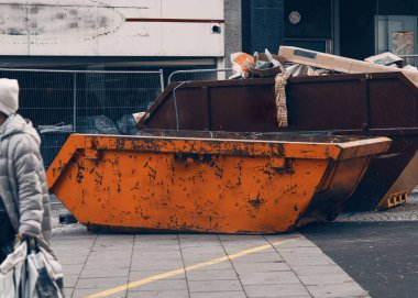 Turuncu atık ve geri dönüşüm turuncu atlama kaldırım üzerinde şehir merkezinde inşaat alanının yanında