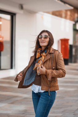 Deri ceketli ve kot pantolonlu Asyalı bir kadın Avrupa 'da dolaşıyor.