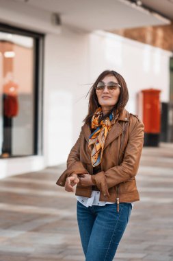 Deri ceketli ve kot pantolonlu Asyalı bir kadın Avrupa 'da dolaşıyor.