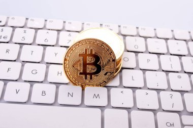 Masadaki beyaz klavyede Bitcoin 'ler