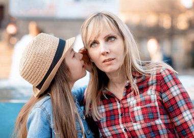 Kızım bir şey söylüyor. Anne şehirde kulağına bir şey fısıldıyor.