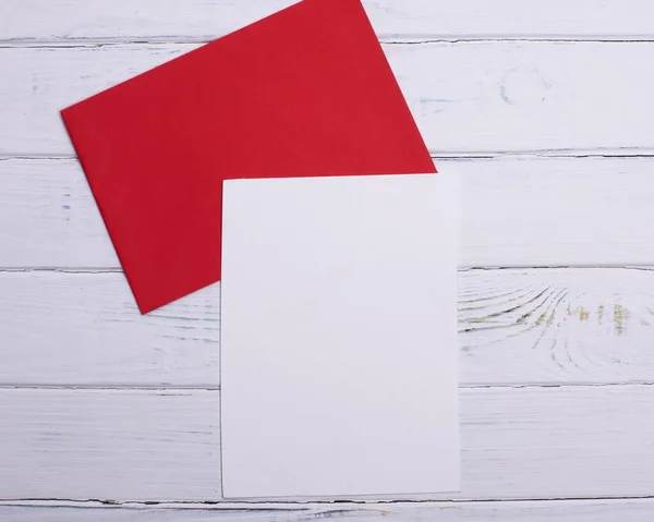 Ein Roter Umschlag Und Weißes Papier Auf Weißem Holzgrund — Stockfoto