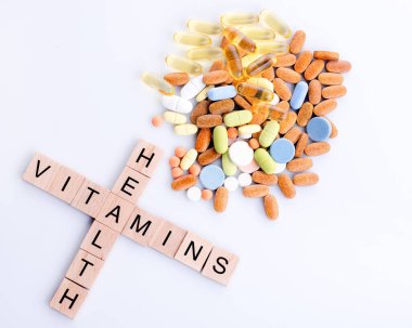 Beyaz arka planda farklı vitaminler ve haplar.