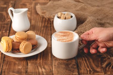 Kahvaltı, kahve, süt ve ahşap arka planda badem kurabiyesi.