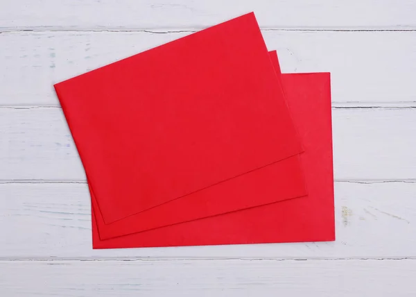 Drie Rode Enveloppen Witte Houten Achtergrond — Stockfoto