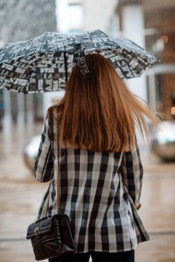 Şemsiyeli kadın şehirde çalışıyor.