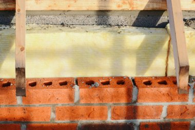Insulating walls of new build houses by placing rock wool inside wall cavities as part of the energy-saving measures close-up. House insulated with mineral wool to reduce energy bill